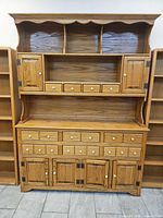 Full front view of oak hutch buffet flanked by two bookcases