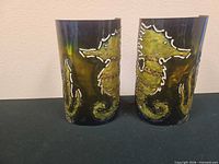 Front view of both metal sconces showing seahorse design