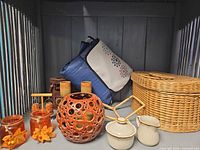 Group shot showing basket, blanket, ceramic pieces, lanterns, glass votives, salt & pepper set