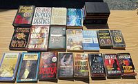 All 23 books laid out on table, showing mix of hardcovers, paperbacks, and Reader’s Digest volumes
