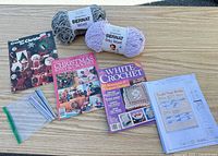 Lot overview showing yarn skeins, magazines, hooks bag, pattern pages