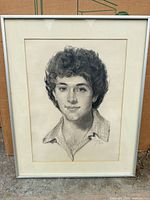 Full view of framed charcoal portrait in silver frame with cream mat
