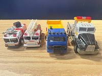 Front view of all four toy trucks side by side
