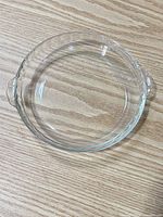 Top view of Pyrex clear glass pie plate showing scalloped rim and handles