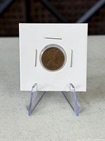 Front view of coin in cardboard flip showing obverse portrait