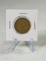Coin in 2×2 holder on stand, obverse visible