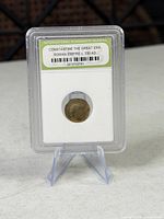 Front of slab showing ancient coin and INB label