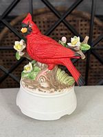 Front view of cardinal figurine on white base showing bird, flowers and branch