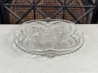 Top view showing entire clear pressed glass divided platter with scalloped edge and starburst centre