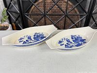 Both oval Blue Willow casserole dishes side by side