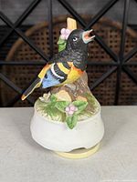 Front view of bird figurine and base