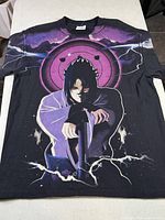 Front view of black Sasuke graphic T-shirt laid flat