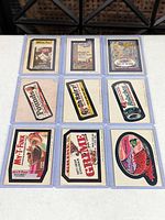 Full view of nine Wacky Packages stickers in 3×3 arrangement, each in a sleeve
