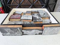 Open box showing full set of wood letterpress blocks with metal plates