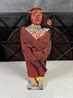 Full view of mother doll wrapped in blanket holding baby