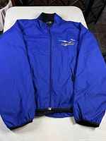 Front view of blue windbreaker jacket showing overall design, zipper and elastic cuffs