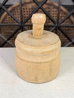 Full view of cylindrical wooden butter mold with plunger inserted