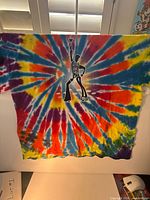 Front of T-shirt displaying tie-dye pattern and event graphic