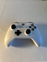 Front angled view of white Xbox controller showing buttons and wear