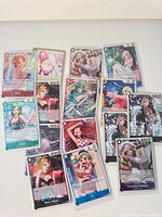 All sixteen sleeved holographic One Piece cards laid out
