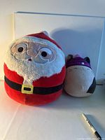 Santa and cat plush toys side by side showing relative size and overall appearance