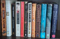 Spines of all 12 books on shelf