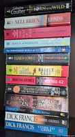 Stack of 13 paperback books showing spines