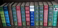 Row of 11 Select Editions hardcovers on shelf, showing spine colors and titles