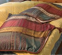 Front view of both pillows showing multicolor geometric jacquard pattern and corded edges