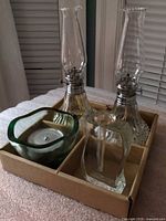 Lot overview showing both oil lamps, green votive holder, perfume atomizer in tray