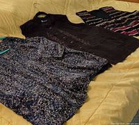 All three garments laid out: patterned blouse, brown embroidered vest, multicolor beaded vest