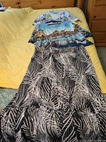 Overview of two tops stacked on leaf-print skirt