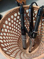 Three Conair curling irons standing in basket