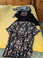 Three tops laid out on bed