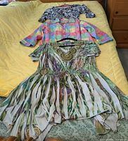 All three tops laid out on bed