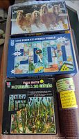 Three boxed puzzles and brown tube displayed together