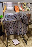 Full view of garment rack with assorted hangers on top bar