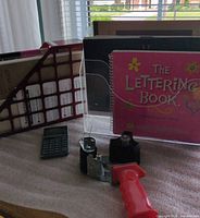 Overall lot with lettering book in acrylic holder, file organizer, calculator, tape dispenser