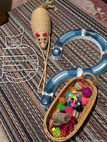 Overall lot showing wire rack, cat track sections, sisal mouse scratcher, basket and assorted toys