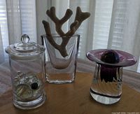 Group shot showing jar with marbles, bud vase with coral, purple art glass piece