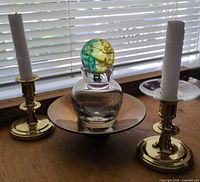 Candlesticks with candles, vase with stopper on dish
