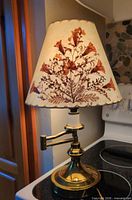 Full view of lamp with shade illuminated on stovetop