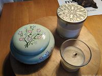 Jar, large candle with lid, small votive on tabletop