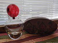 Front view of vase with stopper inserted beside oval wooden box
