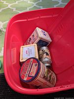Overall lot in red tote showing all tins inside