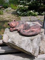Top view of concrete sleeping cat statue on wooden stump