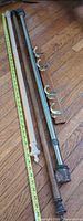 Overview of three curtain rods, wall rack and measuring tape