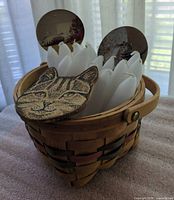 basket filled with candles and cat coasters visible