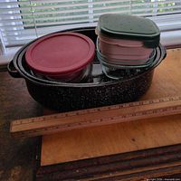 Overall lot showing enamel roaster filled with glass bowls and plastic container