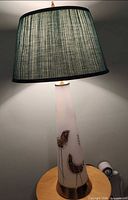 Full lamp showing teal shade and white glass base with bird motif